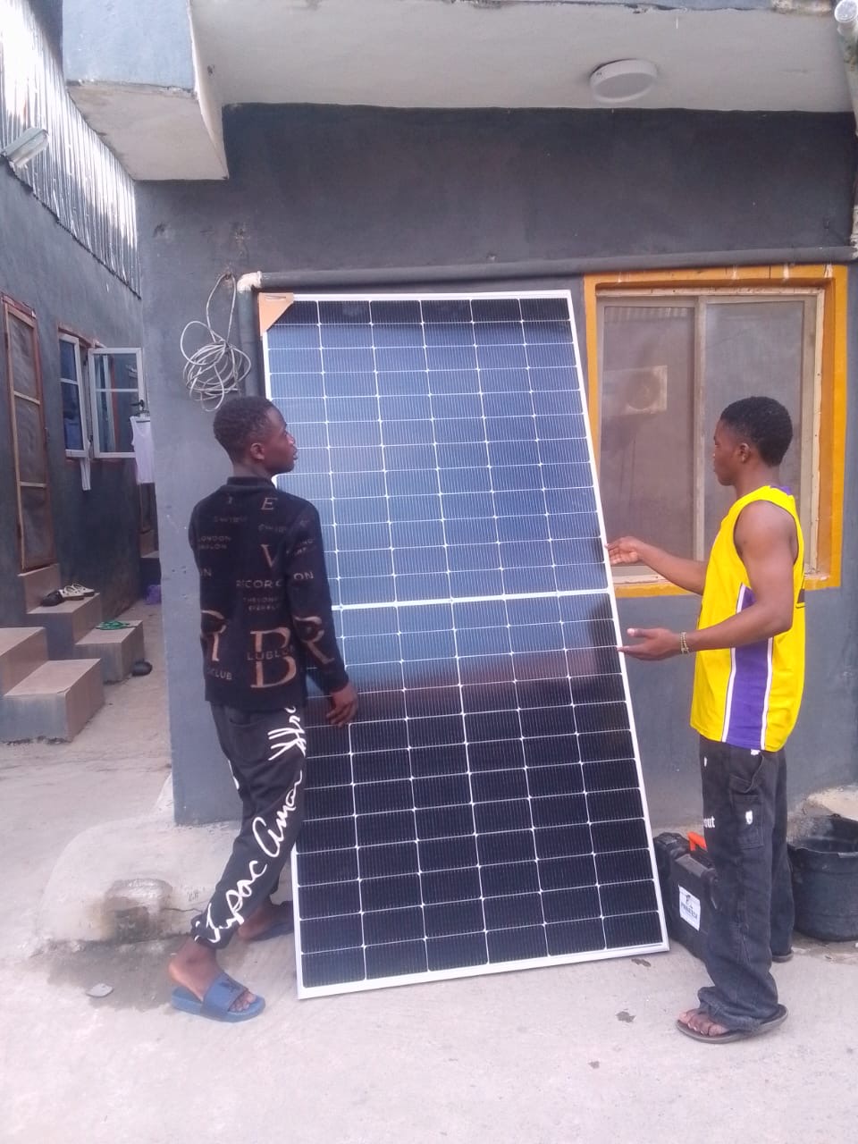 Technicians positioning a large solar panel during installation