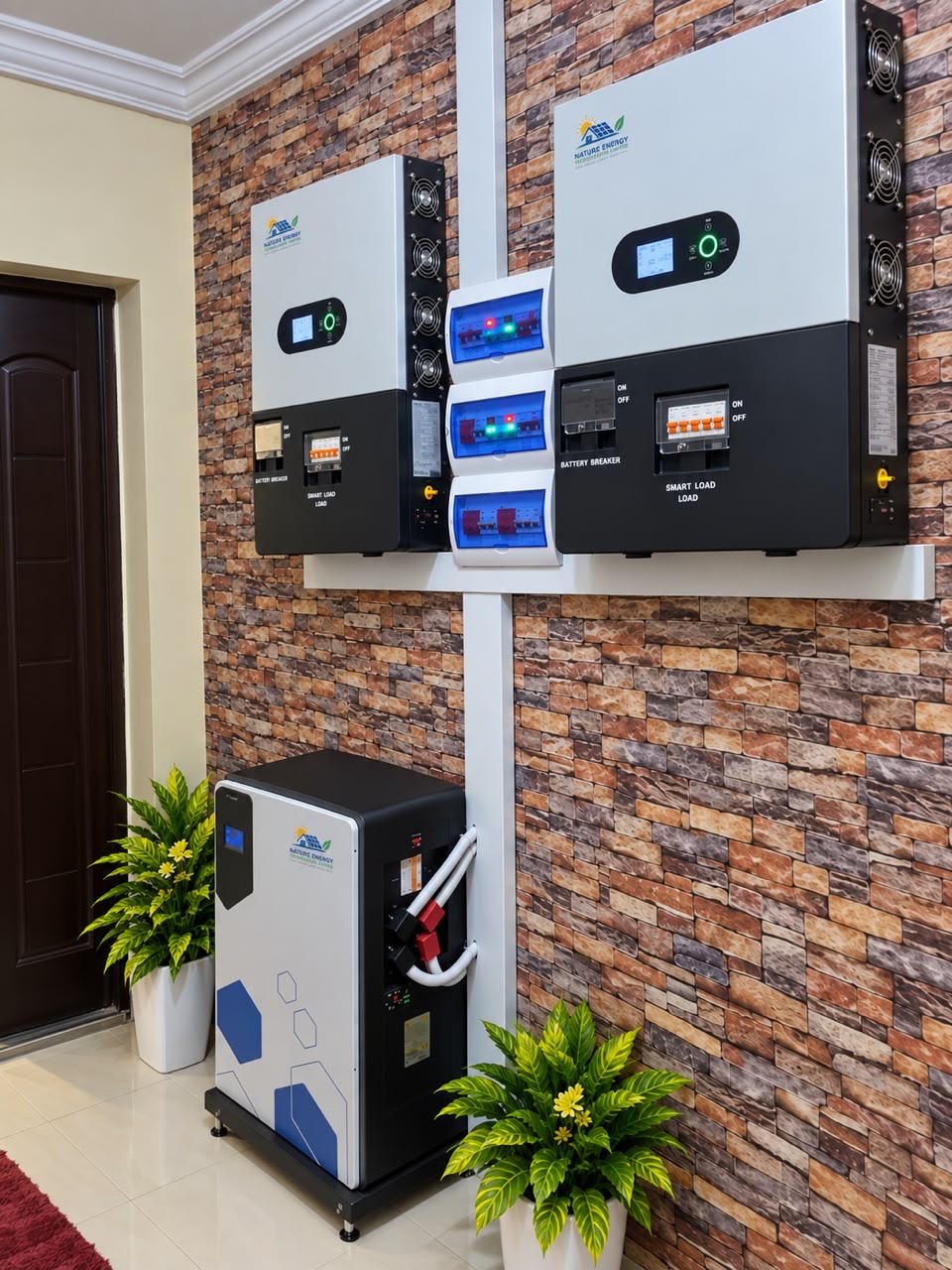 Two hybrid inverters mounted beside battery storage on a brick feature wall